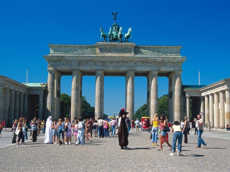 A stunning travel view of Germany featuring the iconic Brandenburg Gate in Berlin, with a European cityscape in the background. The image represents international travel, European tourism, and the opportunity for Nigerian travellers to explore Germany and other Schengen countries.